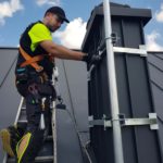 Łukasz Podlewski w trakcie montażu anteny satelitarnej.