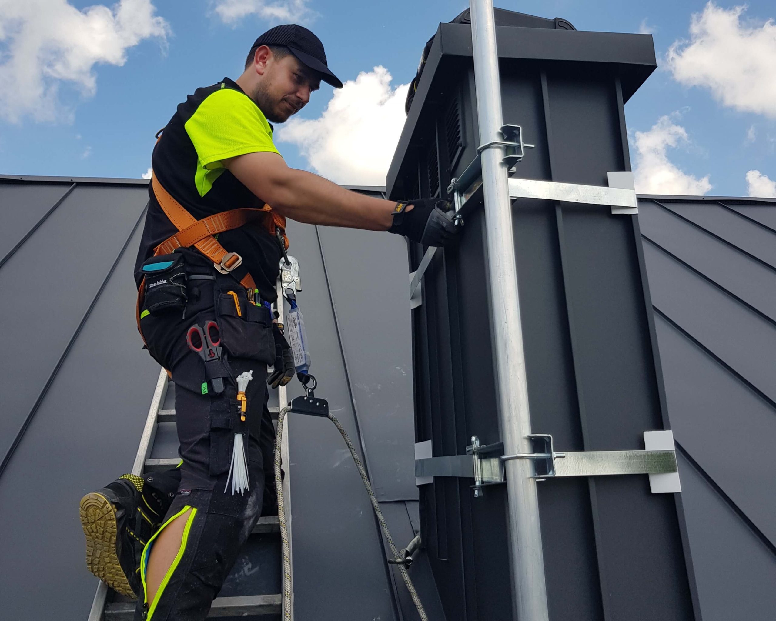 Łukasz Podlewski w trakcie montażu anteny satelitarnej.