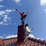 Multitech Łukasz Podlewski w trakcie instalacji anteny satelitarnej.