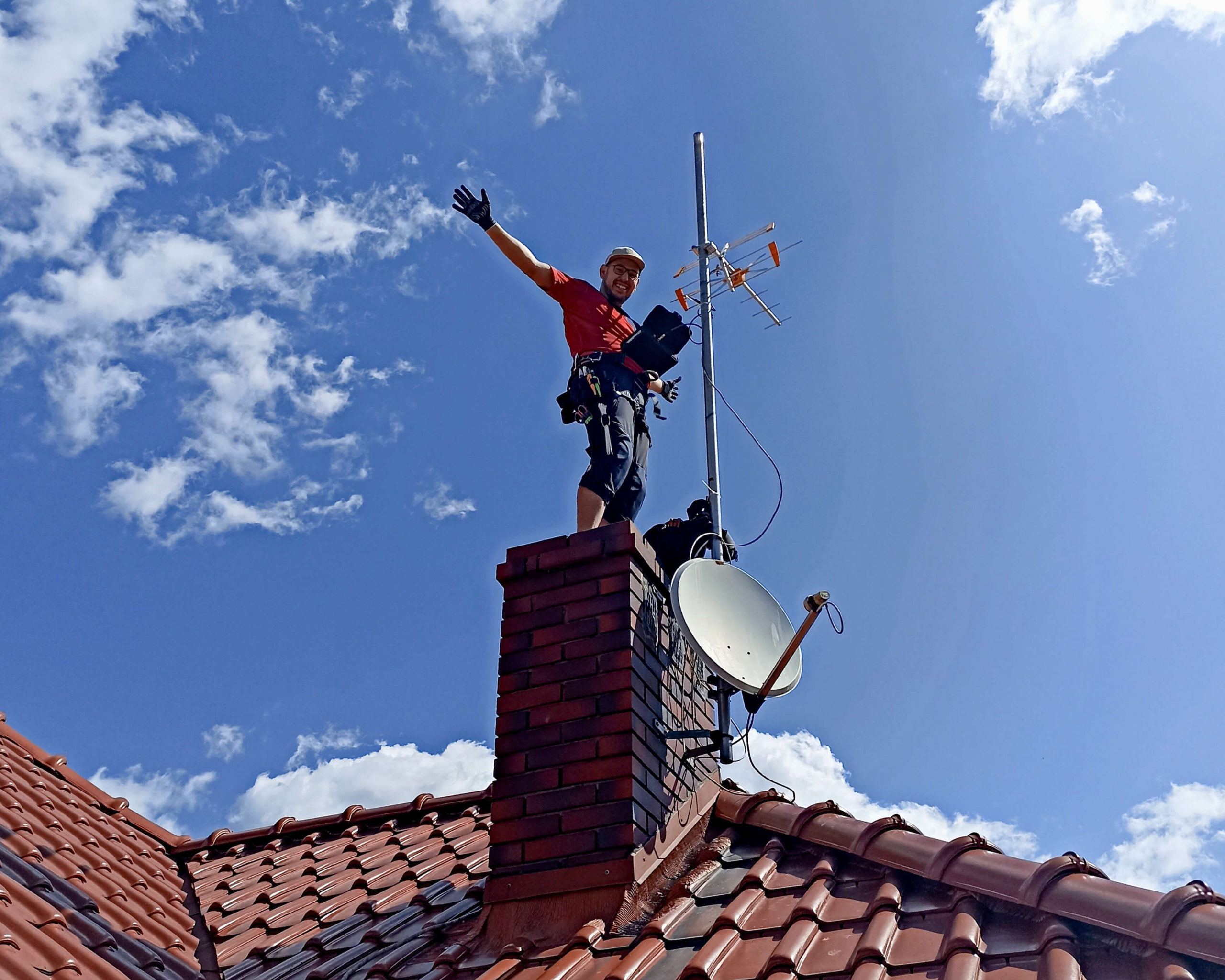 Multitech Łukasz Podlewski w trakcie instalacji anteny satelitarnej.